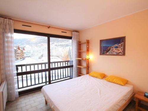 1 dormitorio con cama y ventana grande en Appartement Briançon, 2 pièces, 5 personnes - FR-1-330C-103 en Briançon