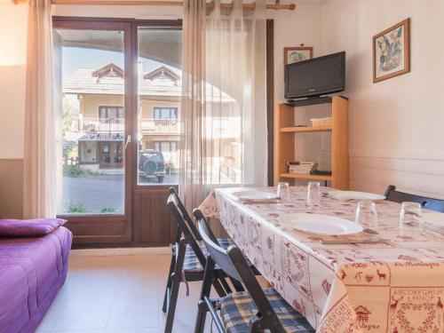 une salle à manger avec une table et une fenêtre dans l'établissement Appartement cosy 5 pers avec casier à skis - Montgenèvre, centre village - FR-1-330D-4, à Montgenèvre