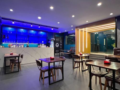 a restaurant with tables and chairs and a bar at Airport Mini Hostel at Don Muang Airport in Ban Don Muang