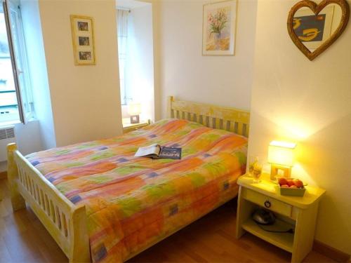 une chambre avec un lit et une table avec un livre dessus dans l'établissement Appartement Centre Luchon, 6 pers, Proche Thermes, Balcon, Parking - FR-1-313-150, à Luchon