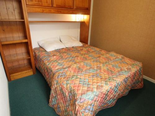 ein kleines Schlafzimmer mit einem Bett mit einem Kissen darauf in der Unterkunft Appartement Bagnères-de-Luchon, 2 pièces, 4 personnes - FR-1-313-185 in Luchon
