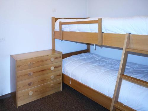 une chambre avec deux lits superposés et une commode dans l'établissement Studio pour 4 avec balcon, accès direct pistes et commerces - FR-1-322-386, aux Orres