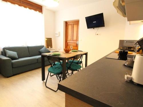 une cuisine et un salon avec une table et un canapé dans l'établissement Studio central cosy pour 2 pers, proche télécabine et thermes, équipé WiFi - FR-1-313-191, à Luchon
