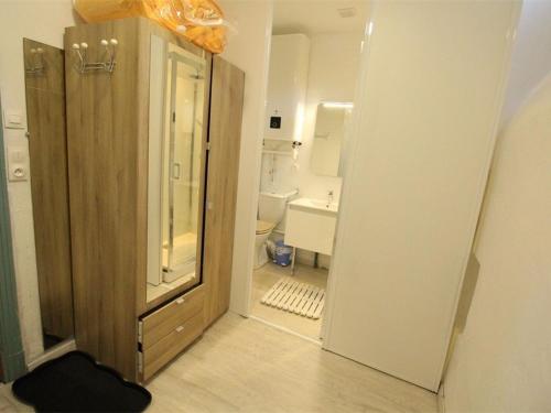 une salle de bain avec un lavabo et des toilettes et une porte dans l'établissement Studio central cosy pour 2 pers, proche télécabine et thermes, équipé WiFi - FR-1-313-191, à Luchon
