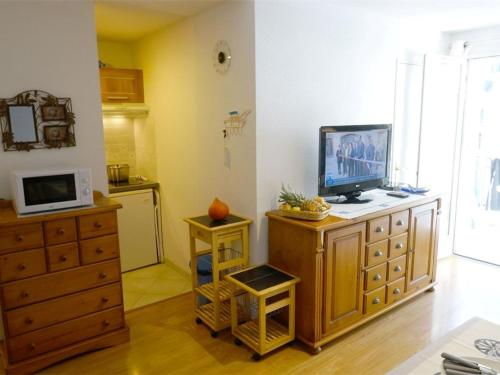 - un salon avec une télévision sur une commode en bois dans l'établissement T2 Calme - Balcon - Parking - Animaux admis - FR-1-313-187, à Luchon