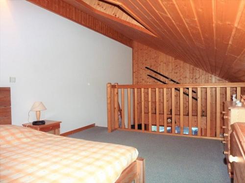 - une chambre avec un lit et un escalier en bois dans l'établissement Location 2 pièces cabine mezzanine à Saint-Jean-d'Aulps, pied de pistes, parking, animaux admis - FR-1-573-29, à Saint-Jean-dʼAulps