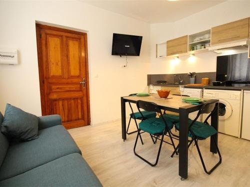 un salon avec une table et des chaises et une cuisine dans l'établissement Studio central cosy pour 2 pers, proche télécabine et thermes, équipé WiFi - FR-1-313-191, à Luchon