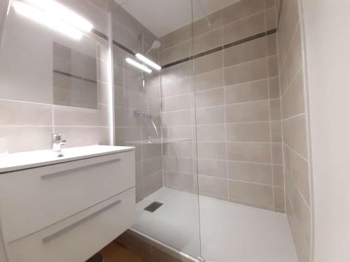 uma casa de banho branca com um chuveiro e um lavatório. em Appartement Saint-Lary-Soulan, 3 pièces, 6 personnes - FR-1-457-246 em Saint-Lary-Soulan