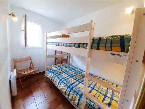 - une chambre avec 2 lits superposés et une chaise dans l'établissement Charmant T3 pour 6 pers à Saint-Lary-Soulan avec balcon exposé sud, parking et casier à skis - FR-1-457-246, à Saint-Lary-Soulan