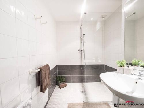 une salle de bain blanche avec un lavabo et une baignoire dans l'établissement Appartement Cozy avec Sauna, Piscine et Proche des Thermes, 4 Pers. à Saint-Lary Village - FR-1-296-328, à Saint-Lary-Soulan