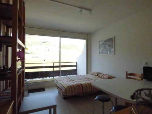 um quarto com uma cama, uma mesa e uma janela em Studio Arette, 1 pièce, 4 personnes - FR-1-602-1 em Arette