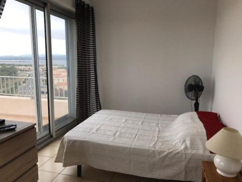 une chambre avec un lit et une grande fenêtre dans l'établissement Grand Studio 4 Pers avec Terrasse et Parking Privé au Barcarès - FR-1-81-485, au Barcarès