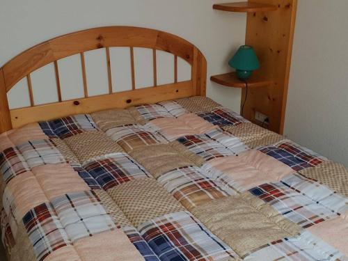 un lit avec une couette dessus dans une chambre dans l'établissement Appartement Centre-Ville 4/6 Pers, 3e Étage, Cuisine Équipée, Parking Gratuit, Linge en Supplément - FR-1-234-228, à Cauterets