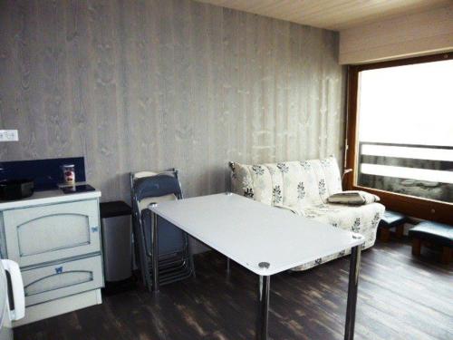 Appartement Arette, 1 pièce, 6 personnes - FR-1-602-34 في أريت: غرفة مع طاولة وأريكة وكرسي