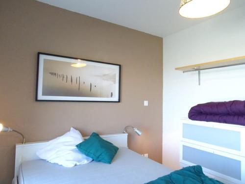 une chambre avec deux lits et un tableau au mur dans l'établissement Appartement cosy 6 pers, accès direct pistes, Arette – TV, cuisine équipée, parking gratuit - FR-1-602-37, à Arette