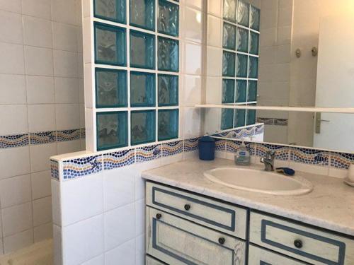 une salle de bain avec un lavabo et un miroir dans l'établissement Spacieux T3 6 pers avec piscine, proche plage - Le Barcarès - FR-1-81-501, au Barcarès