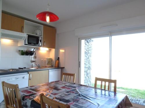 une cuisine avec une table et des chaises et une cuisine avec une fenêtre dans l'établissement Appartement cosy 6 pers, accès direct pistes, Arette – TV, cuisine équipée, parking gratuit - FR-1-602-37, à Arette