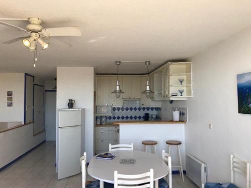 une cuisine avec une table et un réfrigérateur blanc dans l'établissement Spacieux T3 6 pers avec piscine, proche plage - Le Barcarès - FR-1-81-501, au Barcarès