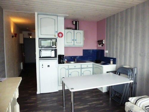 une cuisine avec des armoires blanches et une table à l'intérieur dans l'établissement Studio 6 personnes, balcon, proche pistes et commerces - FR-1-602-34, à Arette