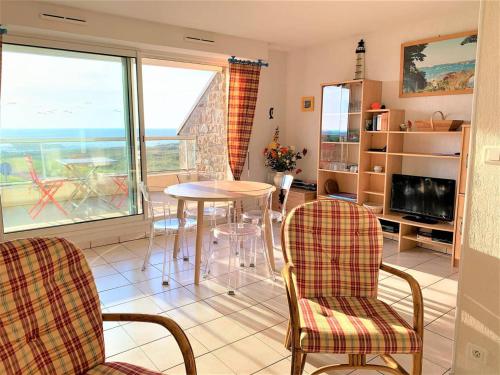 un salon avec une table et des chaises dans l'établissement Studio cabine cosy à Quiberon avec vue mer et garage - FR-1-478-184, à Quiberon
