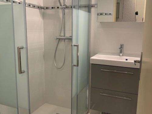 une salle de bain avec une douche en verre et un lavabo dans l'établissement Superbe T3 avec piscine, tennis, parking près de la plage pour 6 pers, terrasse au RDC - FR-1-607-2, au Cap d'Agde