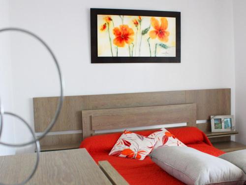 - une chambre avec un lit rouge orné d'une peinture murale dans l'établissement Spacieux T4 climatisé avec parking au cœur de Rochelongue - FR-1-607-29, au Cap d'Agde