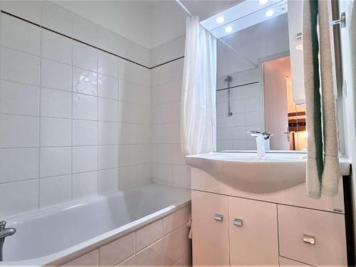 une salle de bain blanche avec une baignoire et un lavabo dans l'établissement T2 Cabine 6 pers avec Balcon, Parking et Casier à Ski, Près des Pistes - FR-1-525-193, à Saint-Étienne-en-Dévoluy
