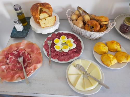 a table with different types of food on plates at BnB La Casina dei Nonni in Campofilone