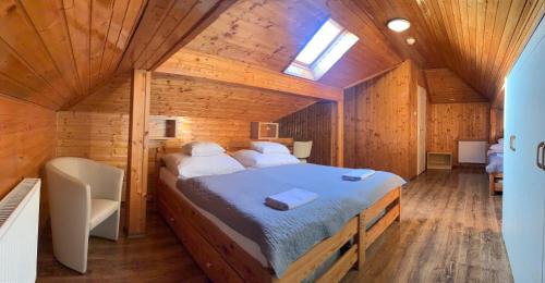 um quarto com uma cama num chalé de madeira em Nimród Hotel és Ètterem em Mosonmagyaróvár