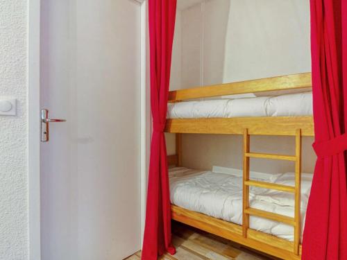 Cette chambre comprend 2 lits superposés dotés de rideaux rouges. dans l'établissement Studio 4 pers - Pied télécabines - Parking - Équipé - WIFI - FR-1-401-208, à Cauterets