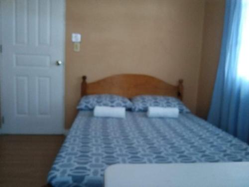 a bedroom with a bed with two pillows on it at Koinonia Retreat CenteR in Baguio