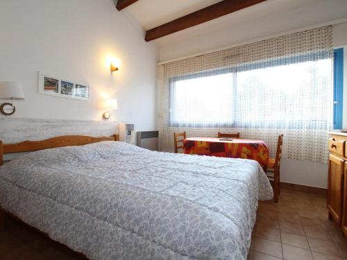 1 dormitorio con cama, ventana y mesa en Studio Balaruc-les-Bains, 1 pièce, 2 personnes - FR-1-553-114, en Balaruc-les-Bains