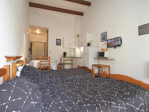 une chambre avec un lit et une cuisine dans l'établissement Grand Studio Climatisé avec Terrasse et Parkings, Proche des Thermes - FR-1-553-106, à Balaruc-les-Bains