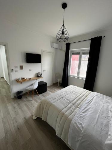 um quarto com uma grande cama branca e uma secretária em Dimora sicula guest house em Catânia