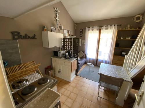 - une cuisine avec une cuisinière et une table dans une chambre dans l'établissement Villa climatisée 4 pers, proche plage, terrasse, Aqualand à 2,5 km - FR-1-81-533, à Leucate