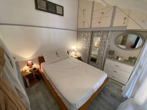 une petite chambre avec un lit et un miroir dans l'établissement Villa climatisée 4 pers, proche plage, terrasse, Aqualand à 2,5 km - FR-1-81-533, à Leucate