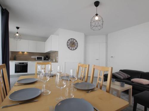 - une table à manger avec des assiettes et des verres à vin dans l'établissement Appartement lumineux 4P/8 pers, 2 terrasses, parking privé, cœur de Briançon - FR-1-330C-119, à Briançon