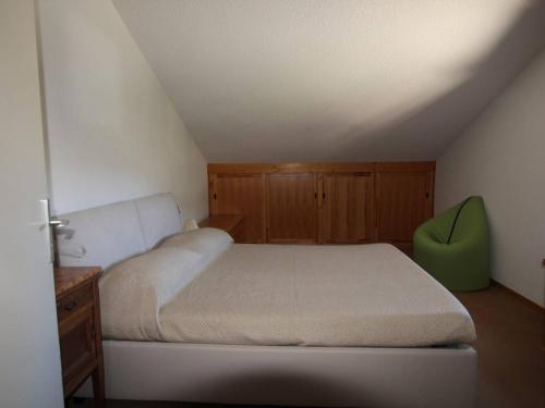 - une chambre avec un lit et une chaise verte dans l'établissement Montgenèvre : Duplex 6 pers, skis aux pieds, proche centre, vue ouest, parking inclus, animaux acceptés - FR-1-330D-113, à Montgenèvre