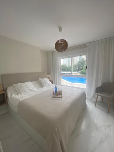 um quarto branco com uma cama grande e uma janela em Casa Bendita - LUXURY APARTMENT BENIDORM em Benidorm