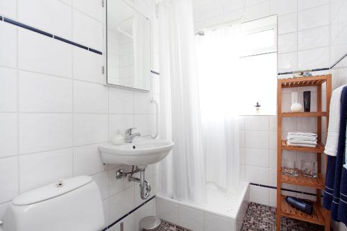 een witte badkamer met een wastafel en een toilet bij Overlooking the city, bright & cozy - Free Parking (A2) in Reykjavík