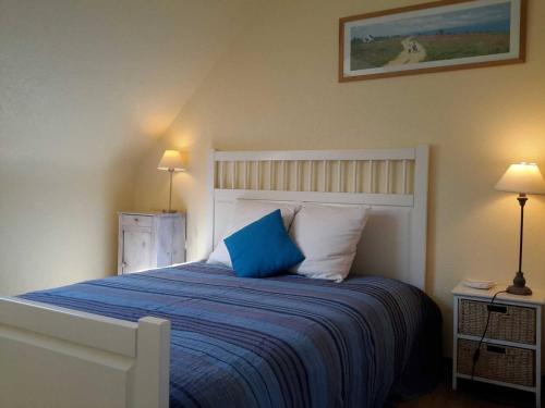 1 dormitorio con 1 cama con almohada azul en Maison Pleumeur-Bodou, 4 pièces, 6 personnes - FR-1-542-28, en Pleumeur-Bodou
