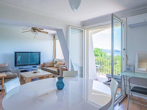 un salon avec une table et une télévision dans l'établissement T3 climatisé à 50m de la plage avec loggia et parking - FR-1-610-69, au Lavandou