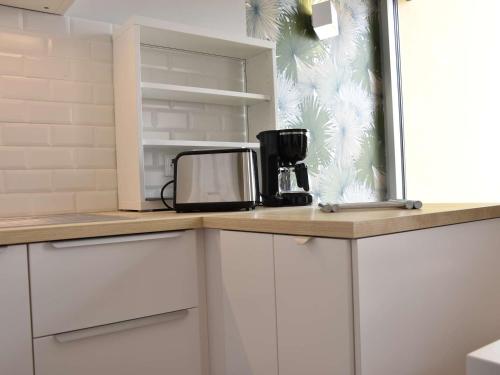 - une cuisine avec un comptoir et une cafetière dans l'établissement Appartement 2 pièces rénové, climatisé, avec balcon et parking privé - 4 couchages, Gruissan - FR-1-229-783, à Gruissan