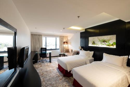 a hotel room with two beds and a television at Mira Business Hotel in Riyadh