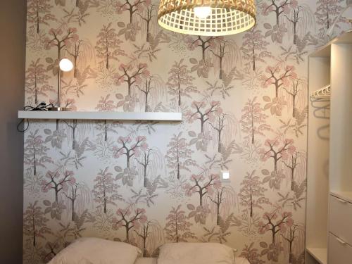 Cette chambre est dotée d'un mur avec un papier peint à fleurs. dans l'établissement Appartement 2 pièces rénové, climatisé, avec balcon et parking privé - 4 couchages, Gruissan - FR-1-229-783, à Gruissan