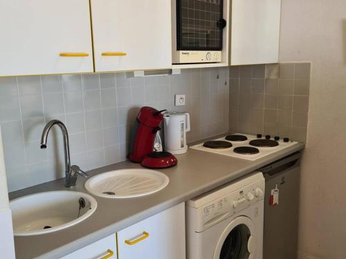 une petite cuisine avec un évier et une cuisinière four supérieur dans l'établissement Appartement pour 6 personnes avec parking à Argelès-sur-Mer - FR-1-388-195, à Argelès-sur-Mer