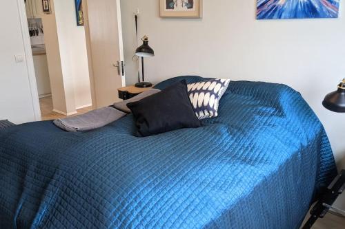a blue bed with two pillows on top of it at Modern and Stylish Reykjavik Apartment in Reykjavík