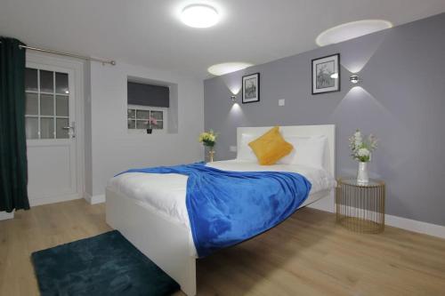 1 dormitorio con 1 cama grande con manta azul en Oasis, Central Self Contained Flat by CozyNest, en Reading