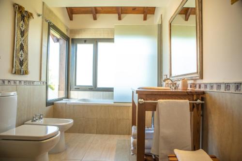 a bathroom with a toilet and a sink and a tub at Lago Rosario Lodge in Trevelín