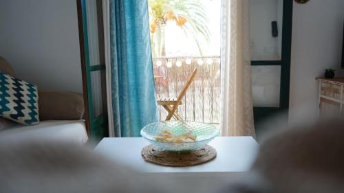 a glass bowl on a table in front of a window at Casa LUNA in Frigiliana